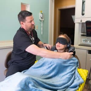 Dr. Mike with Female Patient Covered in Blanket and Eye Covering